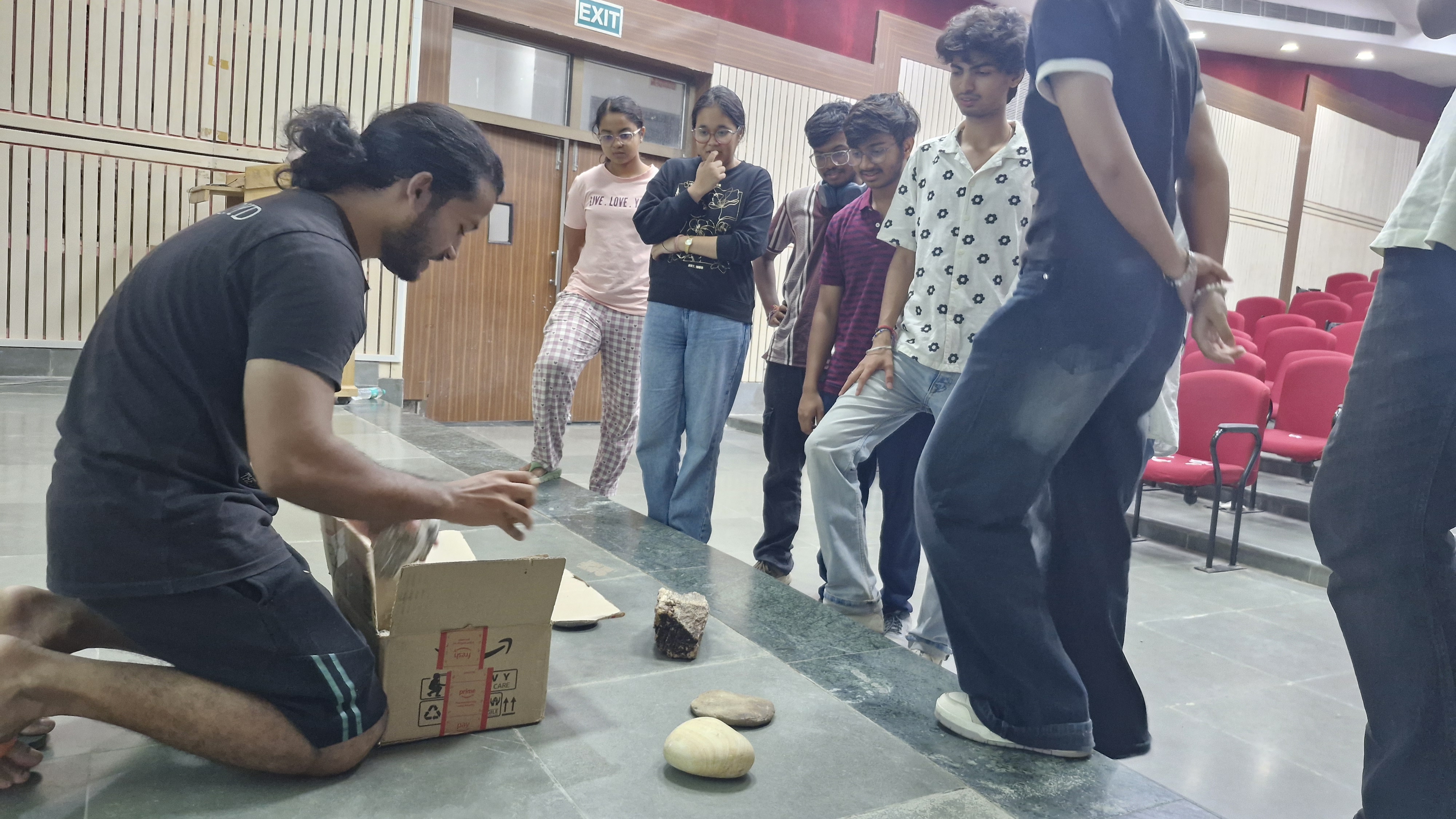 Students gathered around geological samples at an event